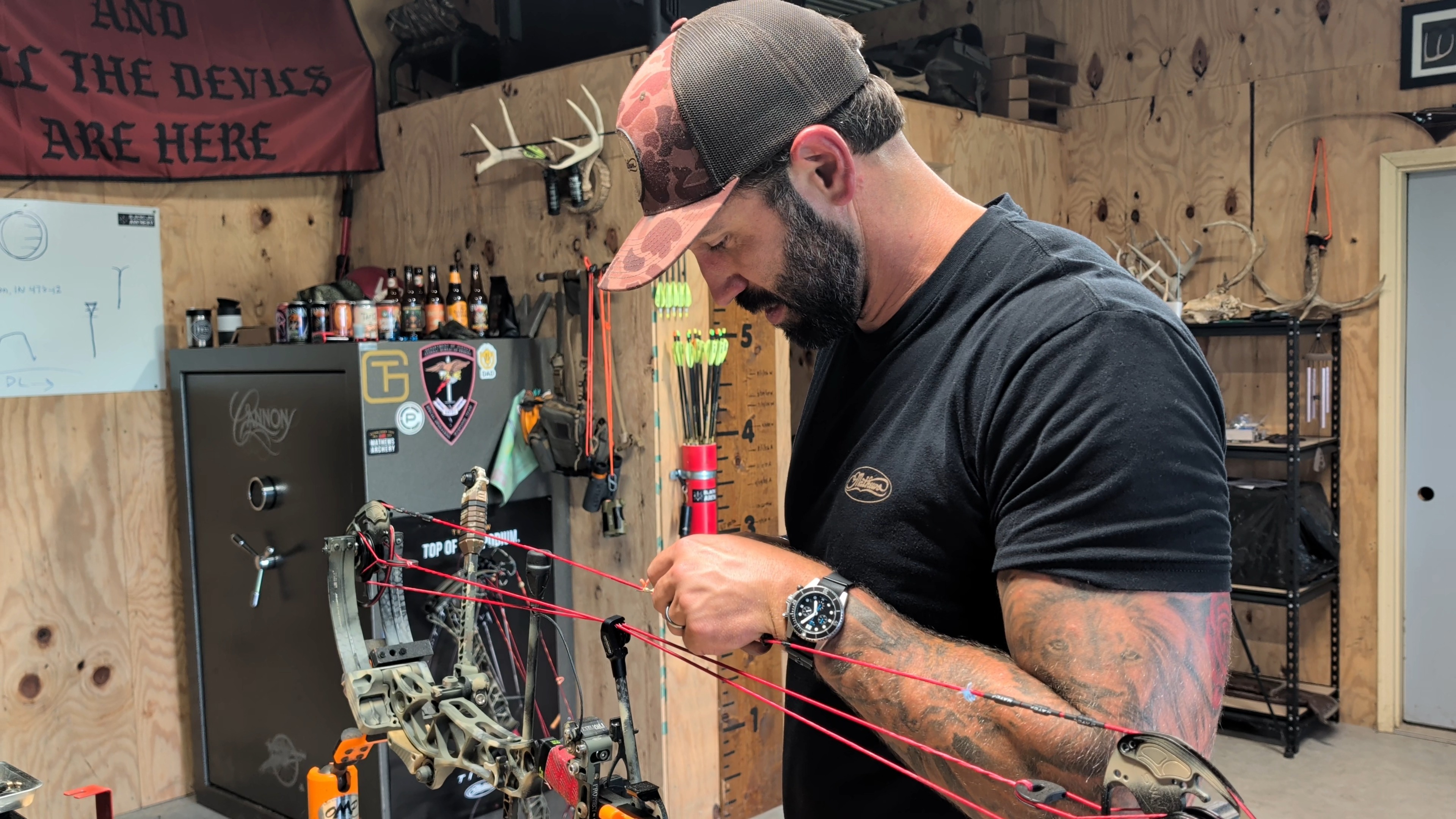 Tharp working on a compound bow at the Black Flag Archery bow bench